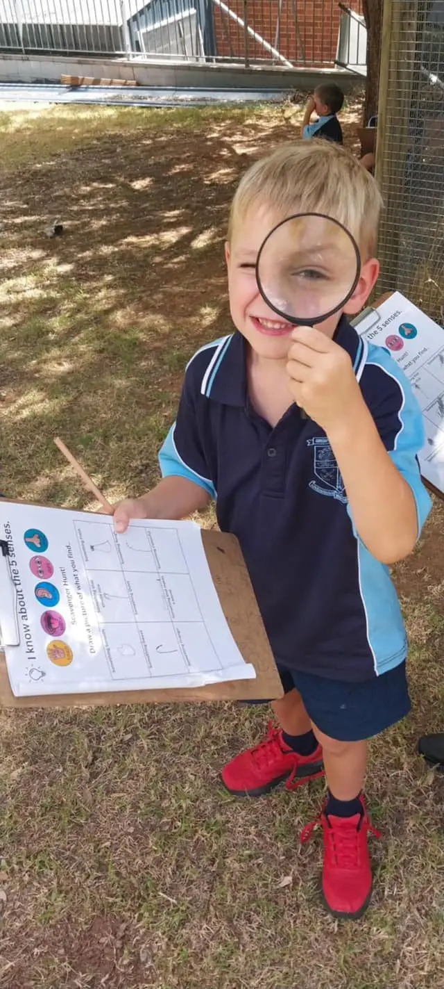 Kindergarten student Lewis explored the living things in the playground as part of the science unit.