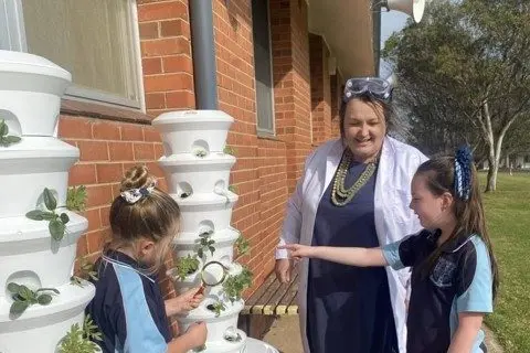 Stage 2 students Octavia D\\u2019Ombrain and Jess Moore check their seedlings in the Airgarden towers with Mrs \\u2018Professor\\u2019 Makin.