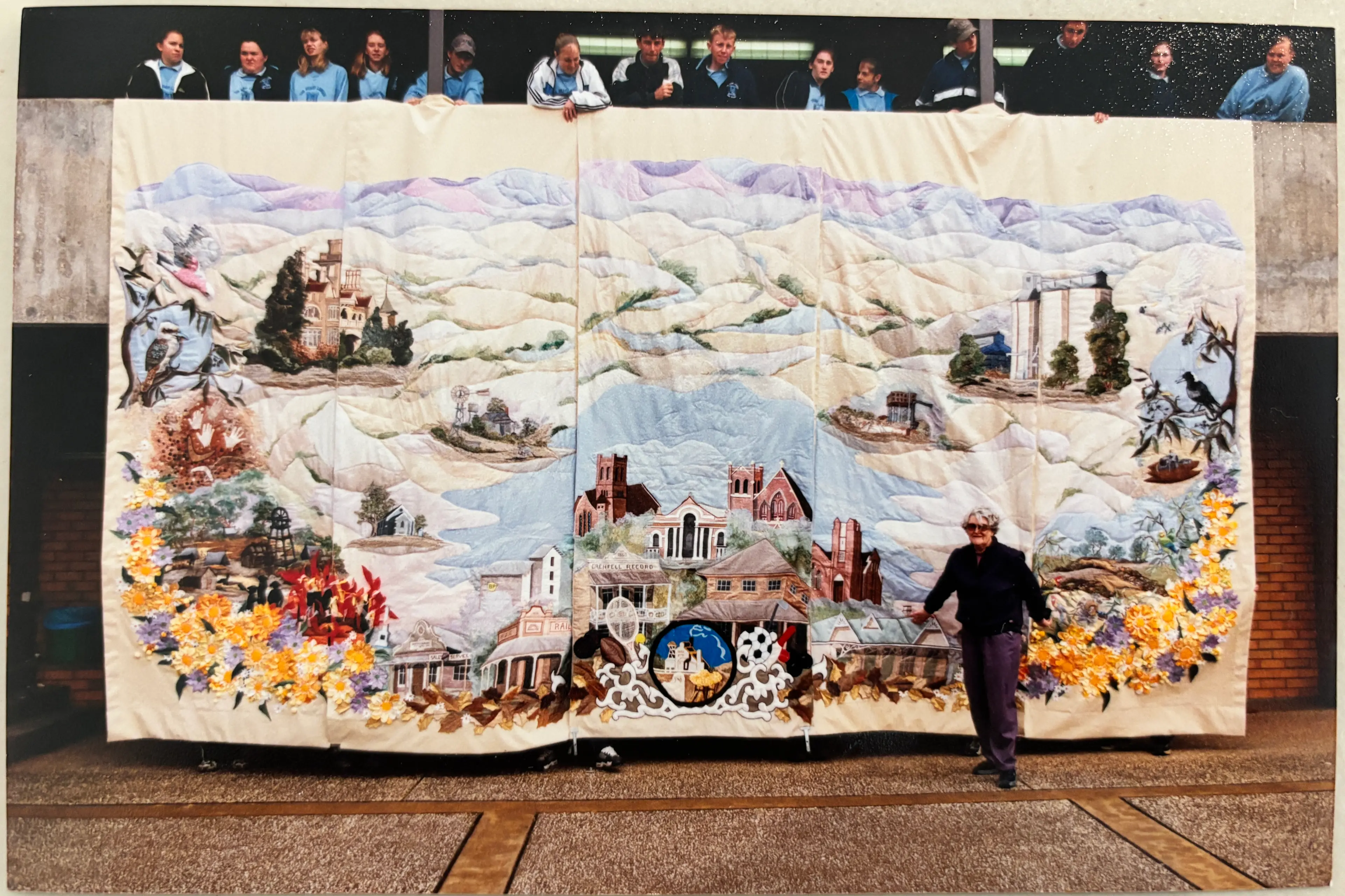 <p>Sylvia Brind with The Henry Lawson High School students in 2000 when the curtain was nearing the end of completion. </p>\\n