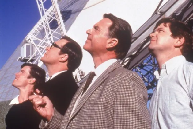 <p>Sam Neill in his role as Cliff Buxton, the lead scientist at the Parkes Radio Telescope in the 2000 Australian movie The Dish, with co-stars Tom Long, Patrick Warburton and Kevin Harrington (right). PHOTO: CSIRO website</p>\\n