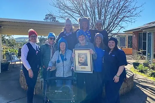 <p>The team at Grenfell MPS and residents celebrating the third annual Kath Bandy Beanie Day last week and Stephen Brandy proudly holding his mum Kath\\'s portrait. </p>\\n