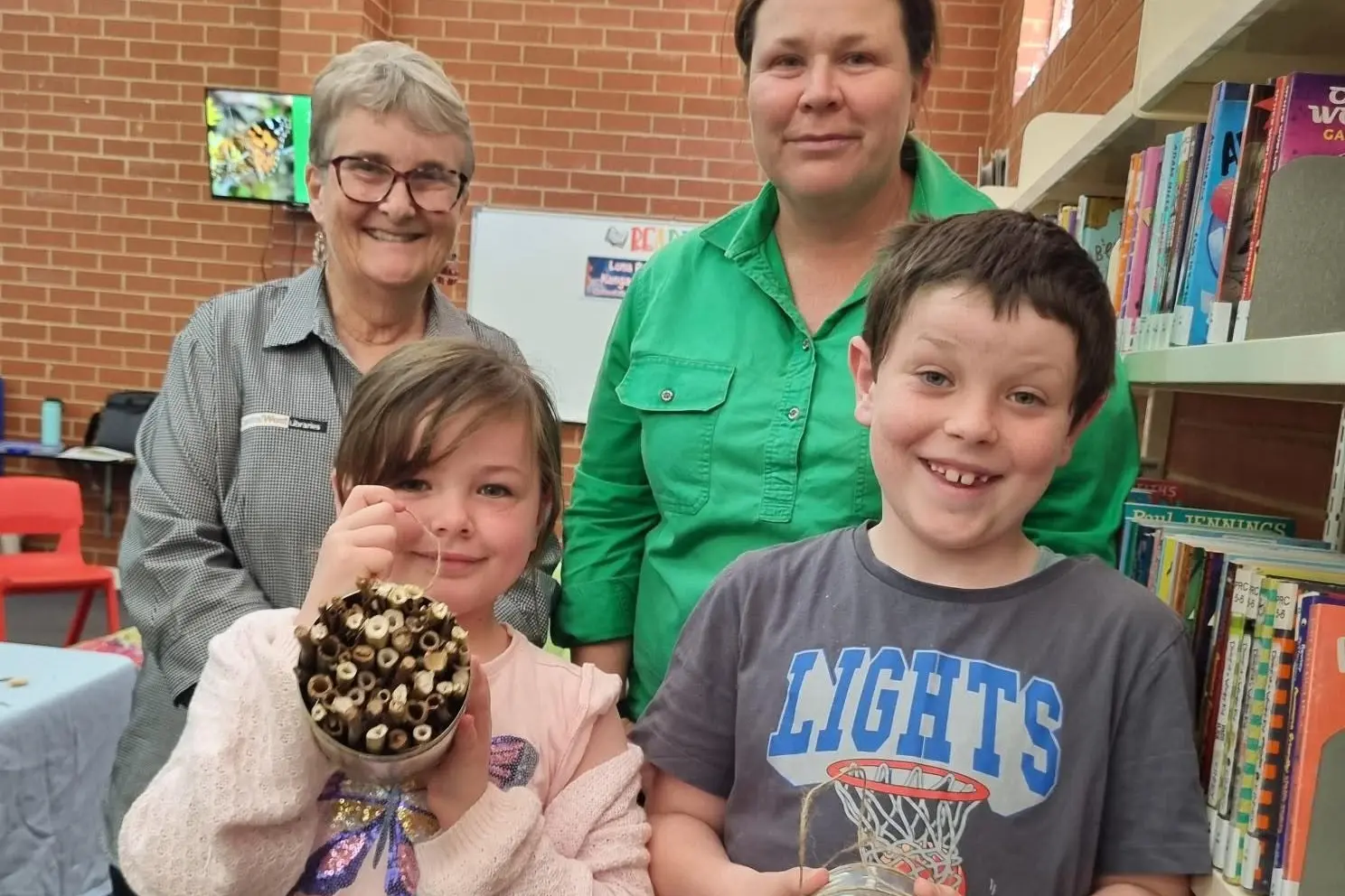 <p>Branch librarian Clenda Wockner and Weddin Landcare\\'s Melanie Cooper with some of the kids who had the chance to learn about bees and make native bee hotels during the school holidays. </p>\\n